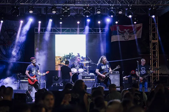 Enjoying a live rock concert at an outdoor venue with vibrant lights and enthusiastic fans