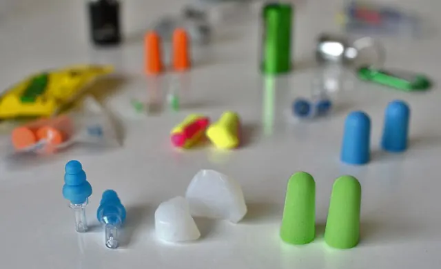 Pair of reusable earplugs beside a gig wristband