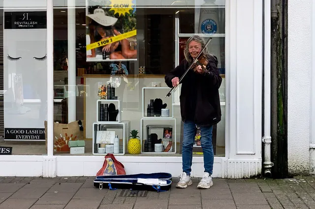 Street musician playing guitar on a city pavement
