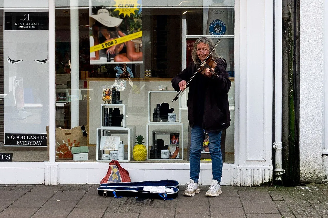 Street musician playing guitar on a city pavement